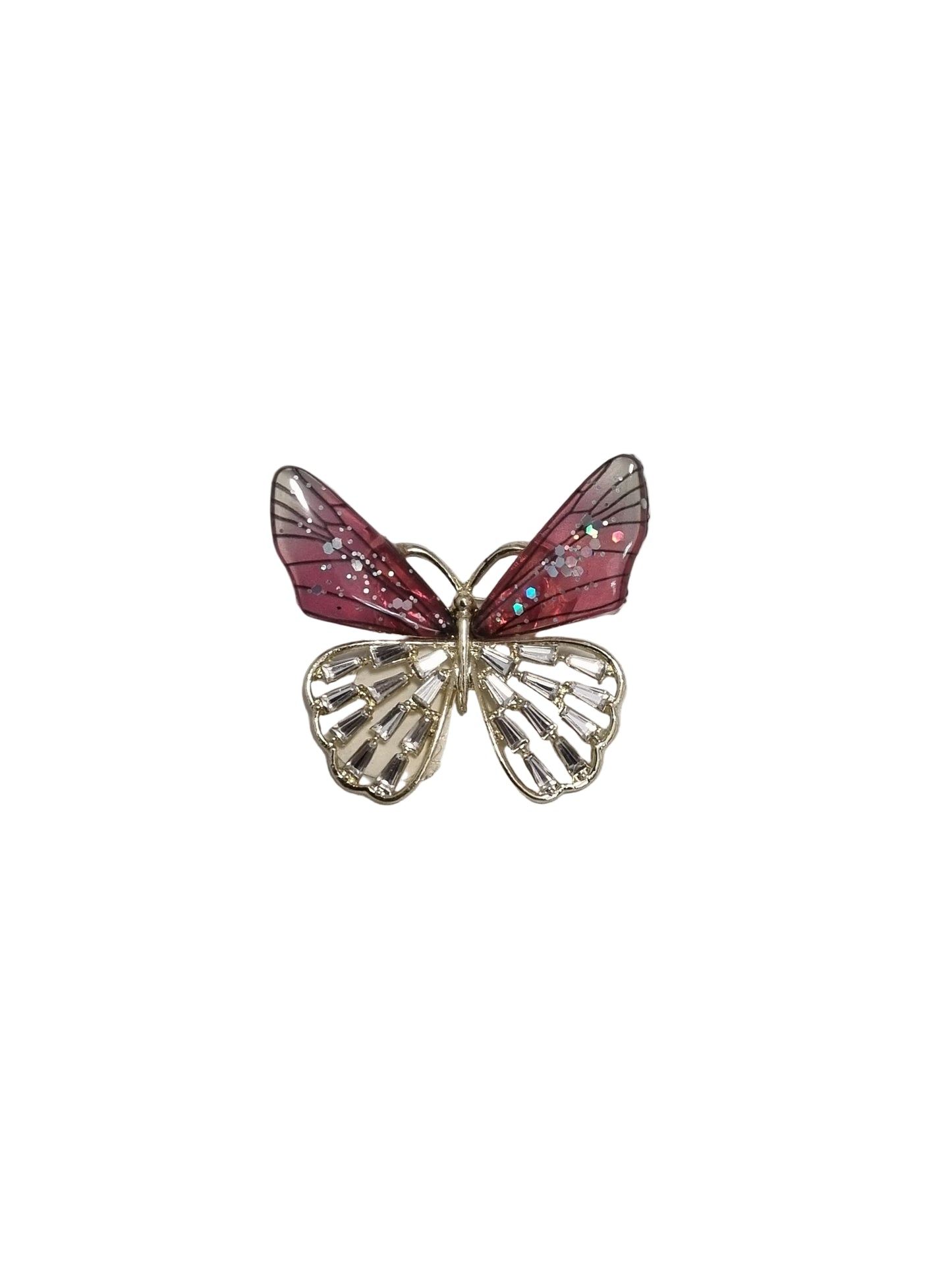 Butterfly-shaped brooch with pink and gold details on a textured gray background
