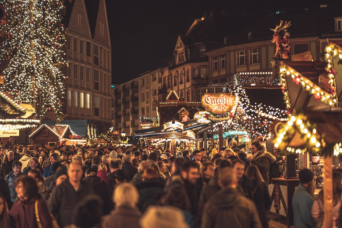 a traditional evening Viennese Christmas market with crowds and lit up stalls