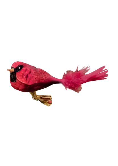 A decorative bird ornament shaped like a cardinal, featuring a glittery pink-red body, fluffy pink tail feathers, a black bib, and gold legs, shown against a plain white background.