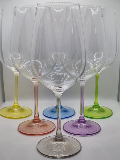 Set of colourful red wine glasses on a white surface