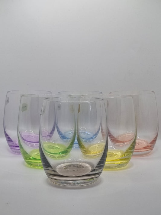 Set of colourful glass whiskey tumblers on a white background