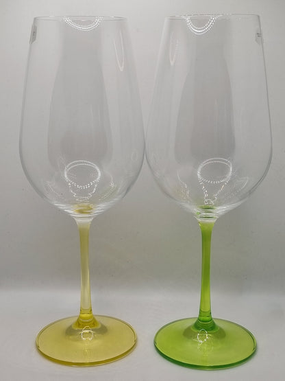 Two red wine glasses with green and yellow stems on a white background